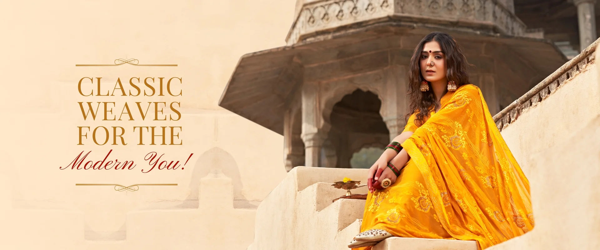 Woman in a yellow saree sitting on steps with text 'Classic Weaves for the Modern You!'
